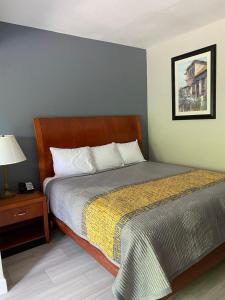 a bedroom with a bed and a table with a lamp at American Way Inn & Suites in Memphis
