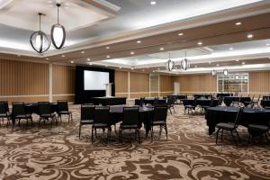 a conference room with tables and chairs and a screen at Sheraton Charlotte Hotel in Charlotte