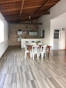 a dining room with a table and white chairs at Casa privado com 3 quartos e piscina in Logradouro