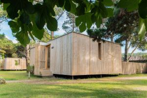 una casa de madera en un patio con una valla en Cabanas Narea en Laxe