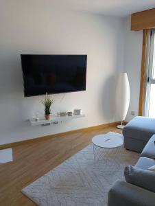a living room with a flat screen tv on a wall at Apartamento Area Maior in Malpica
