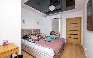 sypialnia z łóżkiem i drewnianym stołem w obiekcie Waryńskiego Jacuzzi FamilyRoom w mieście Białystok
