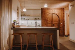 kuchnia z dużą wyspą z stołkami w pokoju w obiekcie SOPA Zakopane w Zakopanem