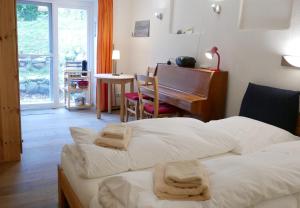 a hotel room with two beds and a piano at Alte Weberei Ahrenshoop - Ort der Erholung in Ahrenshoop