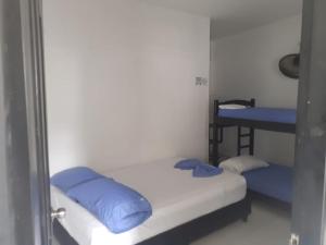 Cette petite chambre comprend deux lits et une table. dans l'établissement Casa - Cabaña ELA en Coveñas, frente al mar, à Coveñas