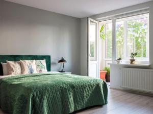 - une chambre avec un lit vert et une fenêtre dans l'établissement Green bed by the pine forest, à Anykščiai