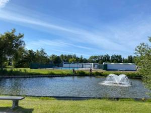 a fountain in a pond in a park at Chalet Dunepark, Oostduinkerke in Oostduinkerke