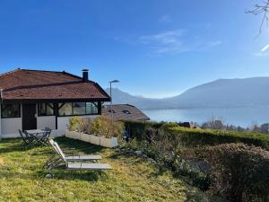 una casa con una mesa y sillas en el césped en Maisonnette vue panoramique lac d'Annecy, en Veyrier-du-Lac