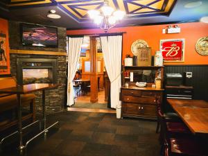 a dining room with a fireplace and a bar at Royal Duke Hotel in Okotoks