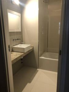 Baño blanco con lavabo y bañera en 3-6 Hermoso Monoambiente baño privado en Buenos Aires