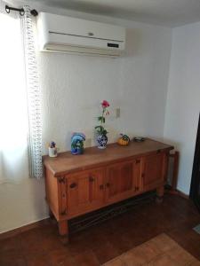 um quarto com um armário de madeira com uma flor em Lush Garden House near beaches with private pool. em Puerto Escondido