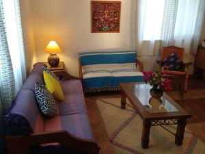 uma sala de estar com um sofá e uma mesa de centro em Lush Garden House near beaches with private pool. em Puerto Escondido