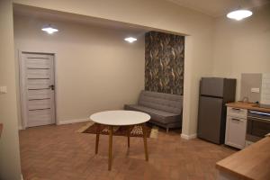 a kitchen with a table and a couch in a room at Apartament Dworcowa in Kalisz