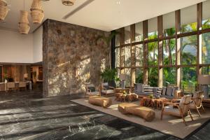 a living room with a large stone wall at Impression Moxché by Secrets - Adults Only in Playa del Carmen
