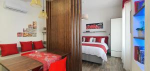 a bedroom with a bed with red pillows and a table at Vatican Apartment St. Peter in Rome