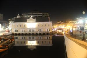 AVEIRO WONDER STAY في أفيرو: مبنى أبيض كبير على الماء في الليل