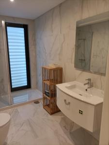 a bathroom with a sink and a toilet and a window at AVEIRO WONDER STAY in Aveiro