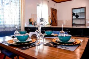 einem Holztisch mit Schalen und Platten darauf in der Unterkunft The Nest Airbnb - Milimani, Kitale in Kitale