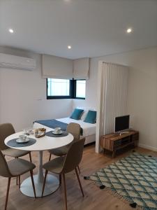 - une chambre avec un lit, une table et des chaises dans l'établissement AVEIRO WONDER STAY, à Aveiro