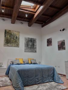 un letto in una stanza con tre dipinti sul muro di Noralù House a Grottaferrata