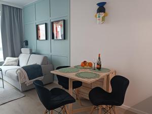 a living room with a table and chairs at Urban Folk Apartament in Gdańsk