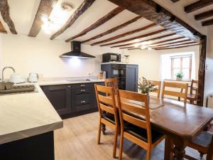 cocina con mesa de madera y comedor en Hen Argoed Cottage, en Llanbedr