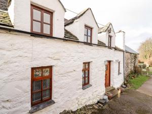Casa blanca con ventanas de madera y entrada en Hen Argoed Cottage, en Llanbedr