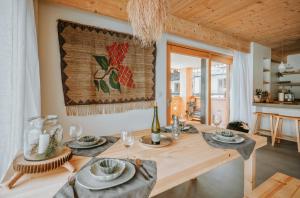 jadalnia z drewnianym stołem z talerzami i kieliszkami do wina w obiekcie SOPA Zakopane w Zakopanem