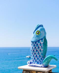 a blue and green bird statue sitting on a table near the ocean at Hotel Ferdinando Beach & Thermal Spa in Ischia