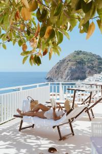 a woman laying in a chair reading a book at Hotel Ferdinando Beach & Thermal Spa in Ischia