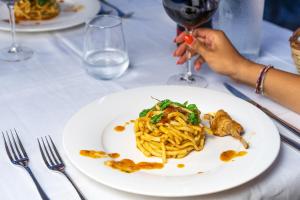a person sitting at a table with a plate of pasta at Hotel Ferdinando Beach & Thermal Spa in Ischia