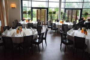 a dining room with white tables and chairs at Bazuny Hotel&Spa in Kościerzyna
