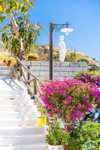 a set of stairs with pink flowers and a statue at Hotel Ferdinando Beach & Thermal Spa in Ischia