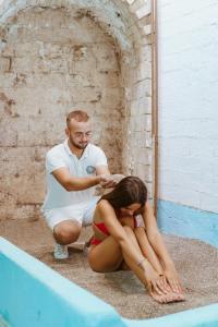 a man cutting a womans hair in front of a swimming pool at Hotel Ferdinando Beach & Thermal Spa in Ischia