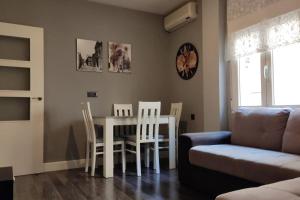 a living room with a table and chairs and a couch at Alojamiento Marmar in Úbeda