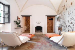 a living room with white chairs and a fireplace at Refugio Son Pons in Campanet