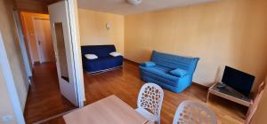 a living room with a blue couch and a table and chairs at Coliwork Le Saint Romain in Dangé