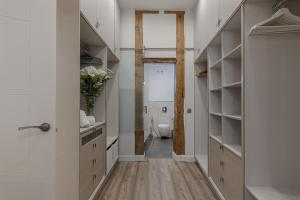 a bathroom with a toilet and a hallway with shelves at BNBHolder Living LA LATINA in Madrid