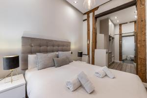 1 dormitorio con 1 cama blanca grande y 2 almohadas en BNBHolder Living LA LATINA, en Madrid