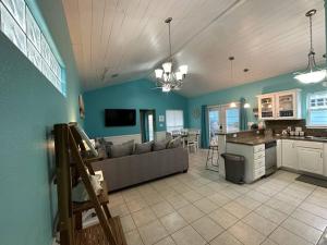 a large living room with a couch and a kitchen at Barefoot Bungalow - Pet Friendly- 2 Bdrm Townhome in Corpus Christi