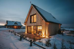 a wooden house with a deck in the snow at SOPA Zakopane in Zakopane