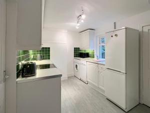 a kitchen with white cabinets and a white refrigerator at Caladh Beag in Lochranza