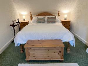 a bedroom with a large bed with a white bedspread at Caladh Beag in Lochranza