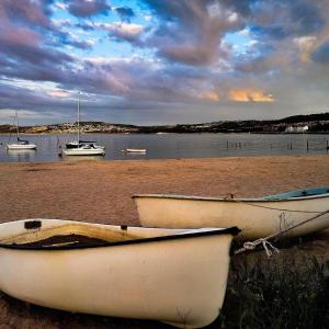 two boats sitting on the shore of a beach at luxury 2 bed apartment, sea view, near the beach. in Llandrillo-yn-Rhôs