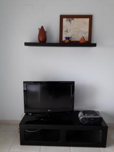 einen Flachbild-TV auf einem schwarzen Entertainment-Center in der Unterkunft BONITAS VISTAS in Peñíscola