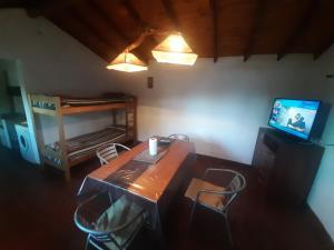 Habitación con mesa de madera y TV. en Esmeralda en San Rafael