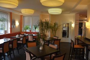 uma sala de jantar com mesas, cadeiras e luzes em Hotel Oyten am Markt em Oyten