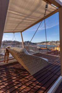 a hammock on a balcony with a view of the ocean at Terrace Douro in Vila Nova de Gaia