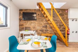a dining room with a white table and blue chairs at Terrace Douro in Vila Nova de Gaia