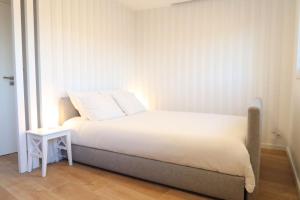 a bedroom with a white bed and a side table at Terrace Douro in Vila Nova de Gaia